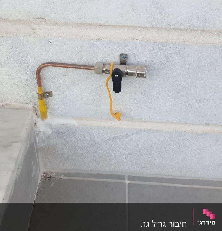 צינור גז עם ברז סגירה על קיר